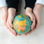 Parent and child holding globe in their hands to represent culture of peace